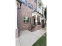 Elegant brick facade with covered entry, enhancing the curb appeal of this meticulously maintained townhome at 209 Snapdragon St, Woodstock, GA 30188