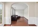 Arched doorway leads to a cozy living room with hardwood floors and a comfortable leather sofa at 250 Kensington Trce, Stockbridge, GA 30281