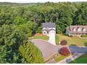 An aerial view shows a home on a tree-lined street, mature trees, and manicured lawns at 7650 Abbey Glen Dr, Cumming, GA 30028