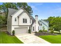 Side angle of charming two-story home with an attached garage and manicured front lawn at 3040 Ivey Oaks Ln, Roswell, GA 30076