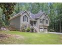 Lush landscaping surrounds this home featuring a two-car garage and inviting front porch at 3365 Ne Ivy Lake Drive Northeast Dr, Buford, GA 30519