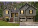 Evening view of the inviting home showcasing a two-car garage and charming front porch at 3365 Ne Ivy Lake Drive Northeast Dr, Buford, GA 30519