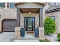 Inviting front entrance with brick columns, decorative planters, and a stylish front door at 206 Traditions Dr, Loganville, GA 30052