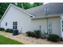 Home exterior featuring neutral siding, gravel landscaping, and visible utilities and external AC unit at 2407 Cove Lake Way, Lithonia, GA 30058