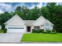 Charming single-story home with well-maintained lawn and two car garage and manicured shrubs at 2407 Cove Lake Way, Lithonia, GA 30058