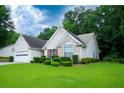 Beautiful single-story home with well-maintained lawn and manicured bushes and a two car garage at 2407 Cove Lake Way, Lithonia, GA 30058