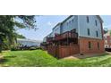 Townhome featuring blue siding, brick foundation, wooden fence, and outdoor decks with views of the green lawn at 5589 Trace Views Dr, Norcross, GA 30071