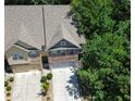 An aerial view of a home showcasing the driveway and mature trees in the surrounding community at 1547 Paxton Sw Dr, Lilburn, GA 30047