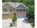 Townhome with attached two-car garage, gray architectural details, and neutral siding in a desirable neighborhood at 1547 Paxton Sw Dr, Lilburn, GA 30047