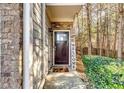 Charming front entrance with a welcome sign, decorative door, and beautiful surrounding greenery at 1547 Paxton Sw Dr, Lilburn, GA 30047