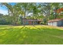Spacious front yard with lush lawn, a home with a red door and a detached garage at 1731 Maryland Sw Ave, Marietta, GA 30008