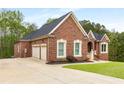 Beautiful brick home boasts an attached two-car garage and well-manicured lawn at 4457 Equity Ct, Ellenwood, GA 30294