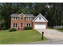Traditional two-story brick house with a manicured front lawn, a red front door, and an attached two-car garage at 1471 Ashwood Way, Lawrenceville, GA 30043