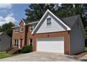 Well-maintained two-story home featuring a brick facade, grey siding, attached garage, and a neatly kept front lawn at 1471 Ashwood Way, Lawrenceville, GA 30043