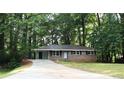Single-story home with a long driveway and lots of mature trees at 4059 Canby Ln, Decatur, GA 30035