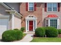 Inviting front entrance featuring a red door with white trim, brick accents, and manicured landscaping at 2113 Soque River Dr, Duluth, GA 30097