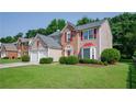 Well-maintained home featuring a two-car garage, brick accents, shutters, and a lush green lawn at 2113 Soque River Dr, Duluth, GA 30097