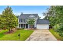 Traditional two-story home with a two car garage and mature landscaping on a sunny day at 3340 Deerwood Ln, Rex, GA 30273