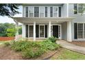 View of the front porch with white columns and black shutters on a sunny day at 3340 Deerwood Ln, Rex, GA 30273