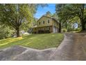 View of home with a concrete driveway leading to a two-car garage, complemented by mature trees and lush greenery at 4819 Elam Rd, Stone Mountain, GA 30083