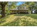 Two-story home featuring brick accents, a welcoming covered porch, beautiful landscaping, and mature trees at 4819 Elam Rd, Stone Mountain, GA 30083