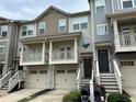 Townhome exterior featuring a two-car garage, balcony, and landscaped front yard at 3015 Liberty Nw Way, Atlanta, GA 30318