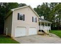 View of the home featuring an attached two-car garage, front porch, and complemented by a well-maintained lawn at 52 Tide Water Way, Rockmart, GA 30153