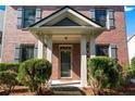 Inviting home entrance with a covered porch, columns, and well-maintained landscaping at 1666 Baxley Pine Trce, Suwanee, GA 30024