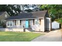 Gray single-story home with a dark roof, cute shutters, and a vibrant blue front door at 3046 Dobbs Way, East Point, GA 30344