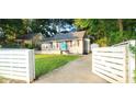 Street view of a cozy home featuring a well-manicured lawn and white wooden fence at 3046 Dobbs Way, East Point, GA 30344