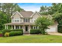 Charming two-story home with a welcoming front porch and manicured landscaping at 345 Riverstone Dr, Hiram, GA 30141