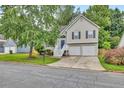 Charming two-story home featuring neutral siding, black shutters, two-car garage, and a well-manicured front lawn at 4435 Grove Nw Dr, Acworth, GA 30101