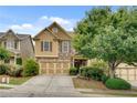 Beautiful home featuring a two-car garage and meticulously maintained landscaping at 8360 Village School Dr, Cumming, GA 30041