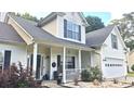 Inviting two-story home featuring a covered front porch with classic columns and an attached two-car garage at 1245 Cedar Oak Ln, Lawrenceville, GA 30043