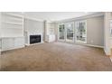 Spacious living room with fireplace, built-in bookshelves, and large windows at 4271 Weston Sw Dr, Lilburn, GA 30047