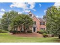 Charming two-story brick home showcasing manicured landscaping and a lush, green lawn in a desirable neighborhood at 11100 Chandon Way, Johns Creek, GA 30097