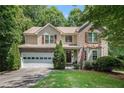 Charming two-story home featuring a well-manicured lawn, a two-car garage, and a welcoming front porch at 1625 Rushing River Way, Suwanee, GA 30024