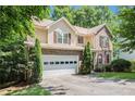 Charming two-story home with two-car garage featuring a well-manicured lawn, and front porch at 1625 Rushing River Way, Suwanee, GA 30024