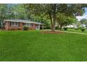 Manicured front lawn and mature trees surround a classic single-story brick residence at 2858 Valley Ridge Dr, Decatur, GA 30032
