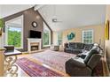 Spacious living room with a fireplace, large windows, and comfortable seating area with a leather sectional at 638 Glen Valley Way, Dacula, GA 30019