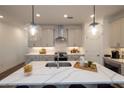 Bright kitchen featuring quartz countertops, stainless steel appliances, pendant lighting, and a central island at 1007 Crown Oak St # 45, Johns Creek, GA 30022