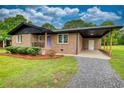 Inviting brick home features a covered carport and cozy front porch at 370 Walnut St, Social Circle, GA 30025