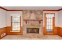 Living room displaying a stone fireplace with a wooden mantel, flanked by two windows at 402 Princeton Way, Lawrenceville, GA 30044