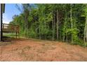 A spacious backyard with a wooden deck extending from the home, surrounded by lush trees at 4095 Oriole Ln, Fairburn, GA 30213