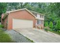 Charming two-story brick home featuring an attached two-car garage and a well-manicured lawn at 574 Hickory Hills Ct, Stone Mountain, GA 30083