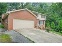 Charming two-story brick home featuring an attached two-car garage and a well-manicured lawn at 574 Hickory Hills Ct, Stone Mountain, GA 30083