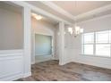 Elegant dining room featuring decorative molding, modern chandelier, and expansive windows at 267 Eason St, Bowdon, GA 30108
