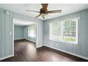 Bright dining room featuring a ceiling fan, wood floors, and view to the yard through large window at 3551 Clay Rd, Austell, GA 30106