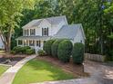 Charming two-story home exterior with manicured lawn, mature trees, and a paved driveway for easy parking at 6065 Ashbury Ln, Cumming, GA 30028
