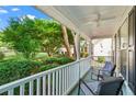 Relax on this covered front porch with comfortable seating, offering serene views of the lush, green surroundings at 6065 Ashbury Ln, Cumming, GA 30028